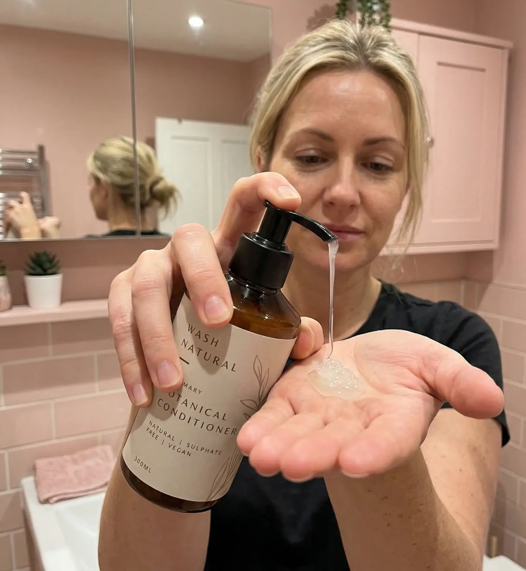 Creator demonstrating botanical conditioner in a bathroom
